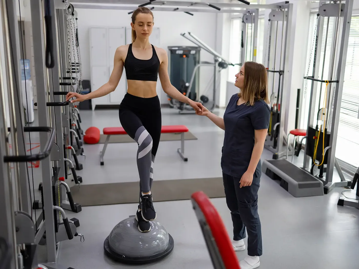 Therapist supervising gait training in a rehab gym