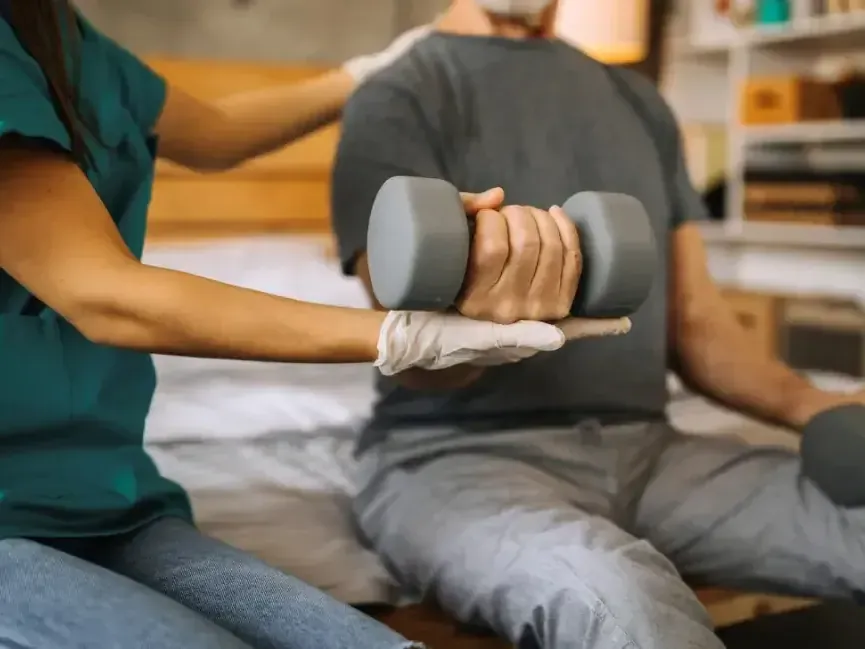 Clinician guiding a patient through a wrist and hand strengthening exercise