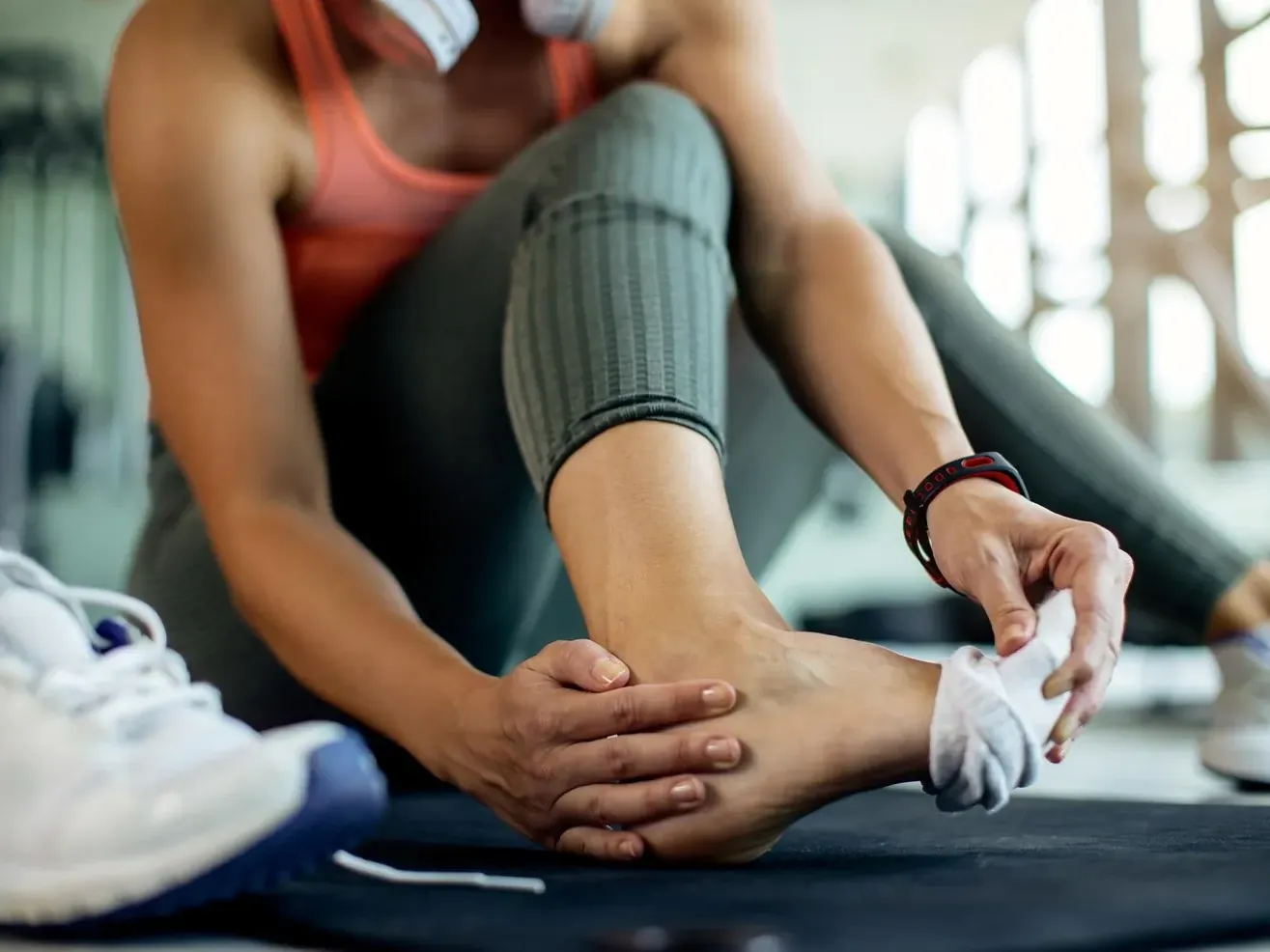Athlete holding her ankle after a workout