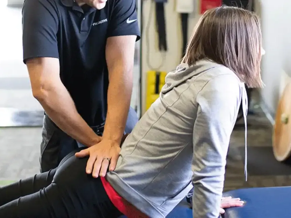 Therapist assessing a patient's neck and upper back on the treatment table