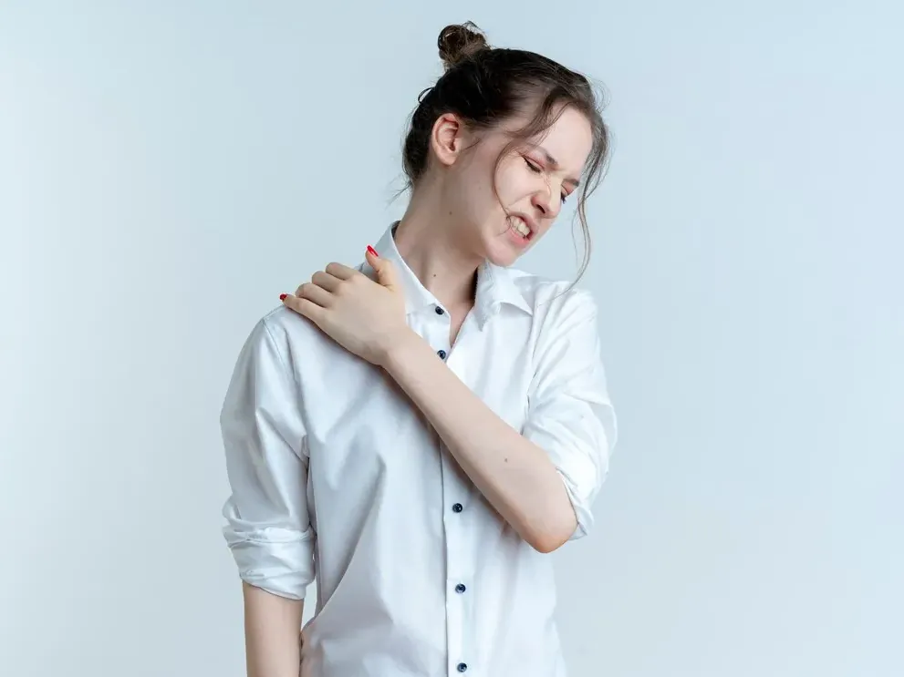 Woman holding her shoulder after reaching overhead