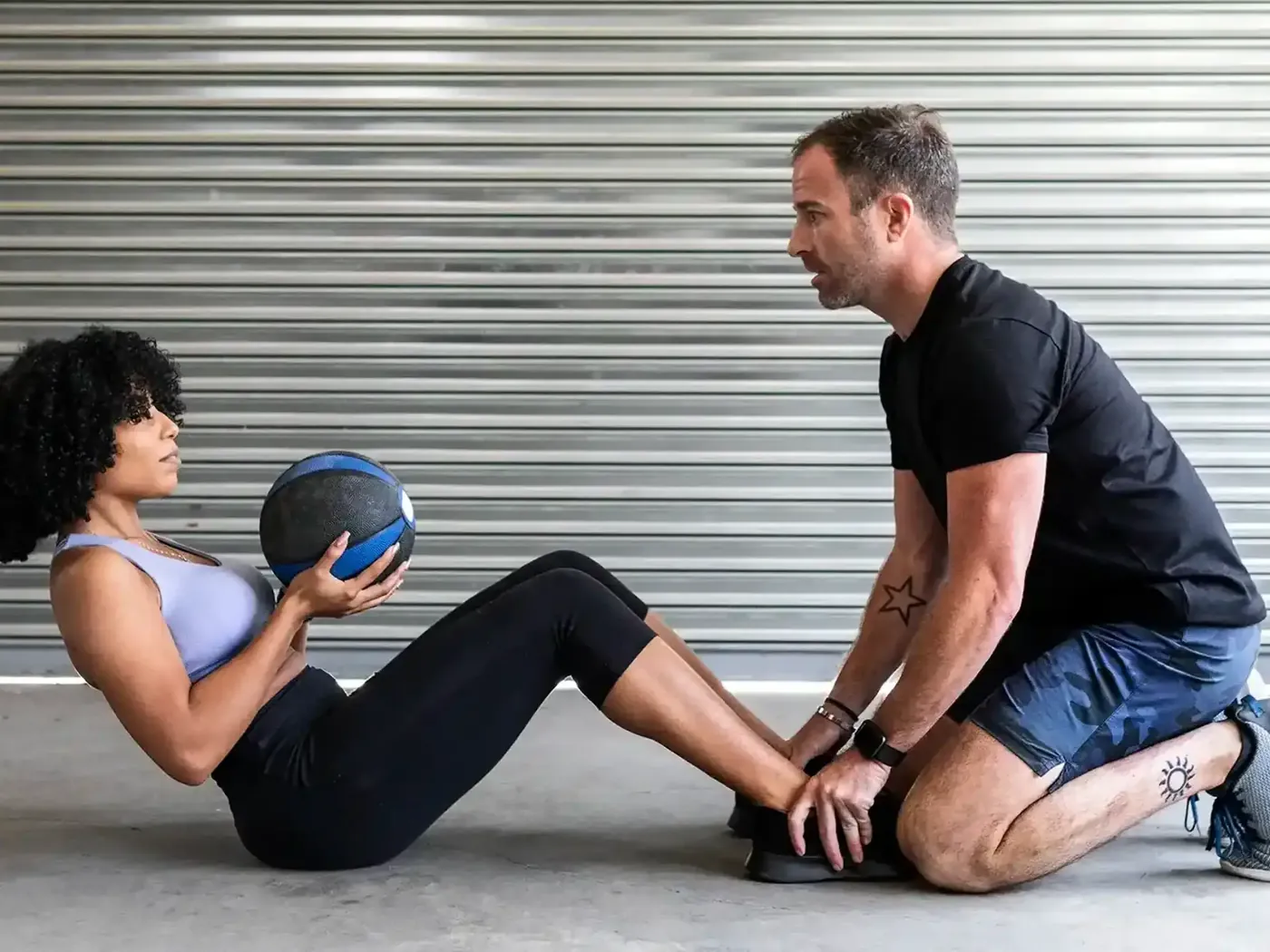 Two people training with a weighted ball to rebuild strength