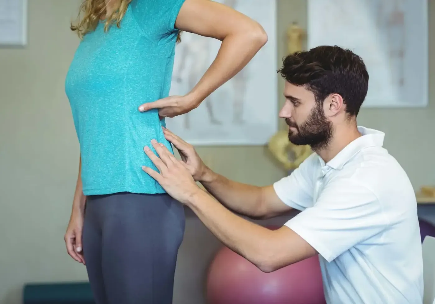 Therapist assessing a patient's lower back on the treatment table